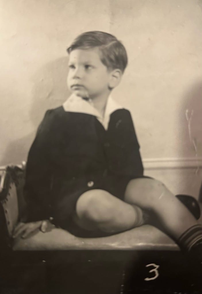Young boy in a suit, sitting on a chair