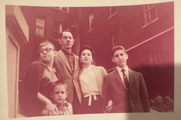 Family of five in front of a brick building